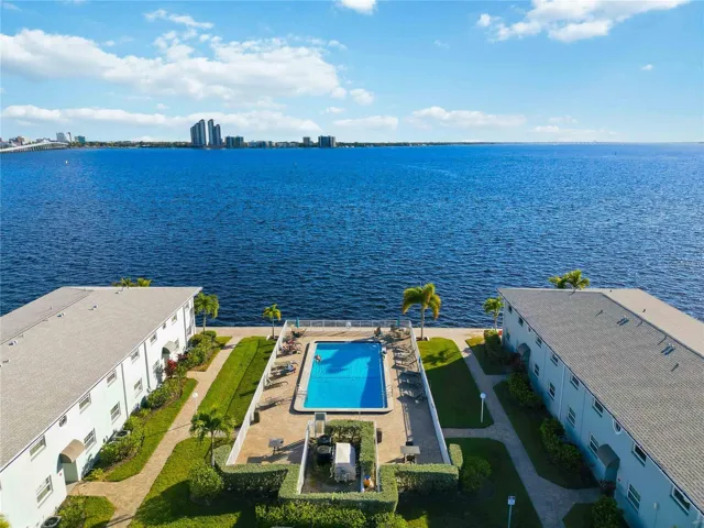 Drone / aerial view of a pool and a nearby body of water