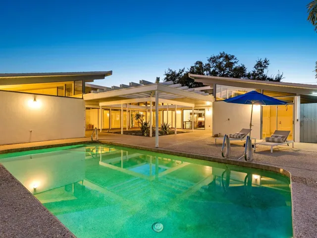 Back corner of property, dusk overlooking pool, with courtyard and inner rooms shown in center