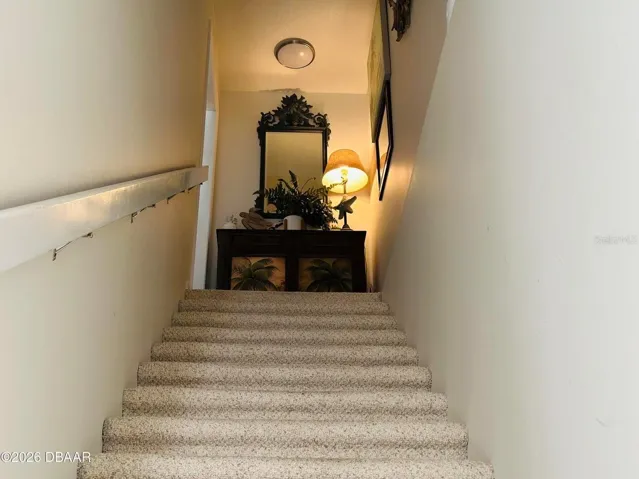 Stairs from main entry door, garage apartment directly to left that has bathroom and kitchen with refrigerator