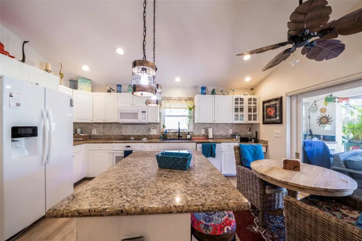 Open kitchen, granite counters, pendant lights, new backsplash and slider to the lanai.