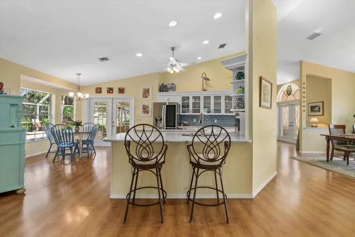 Kitchen with dinette, breakfast bar and french doors to access the pool area