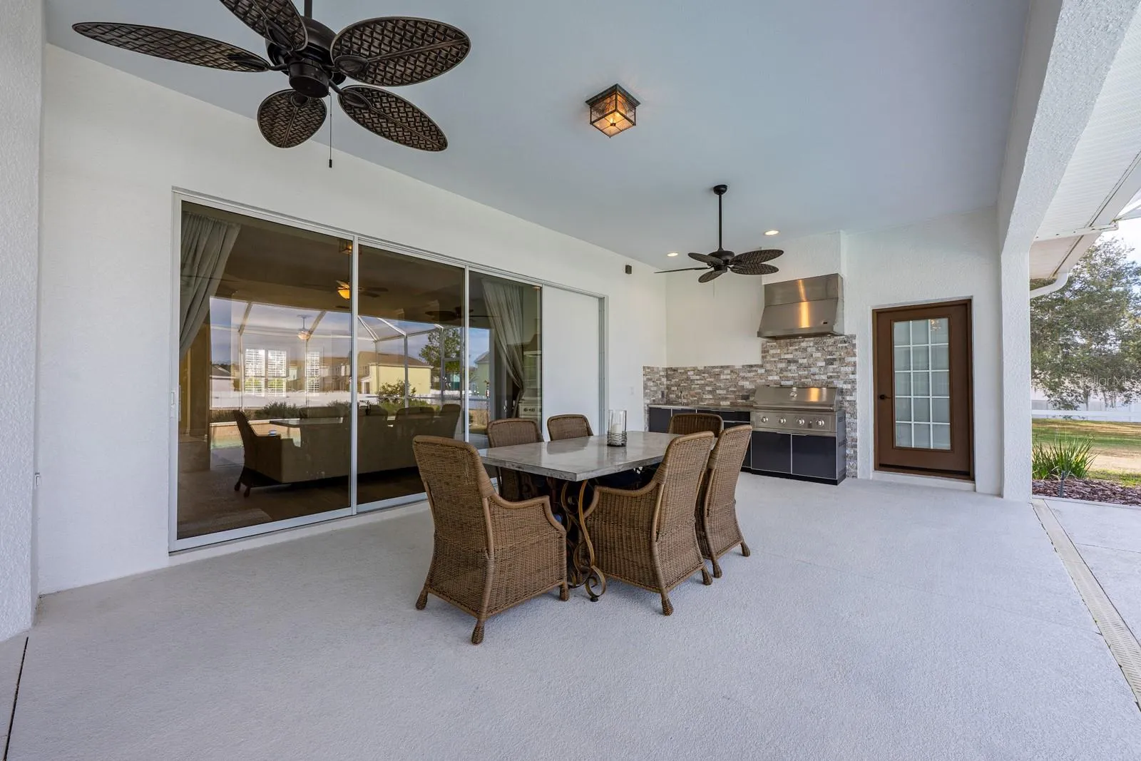 Outdoor living truly shines here - an expansive lanai with a BRAND NEW OUTDOOR KITCHEN  – complete with stone finishes, stainless hood, gas range, sink, and built-in beverage refrigerator – overlooks the HEATED POOL and seemingly endless backyard.