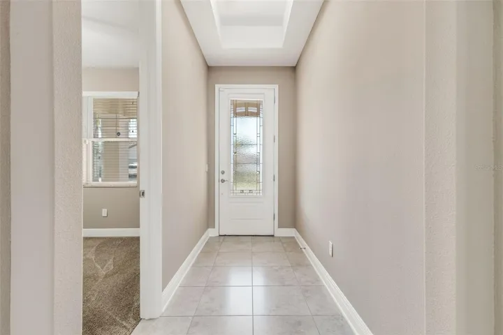 Glass inset front entry door for natural light and privacy.