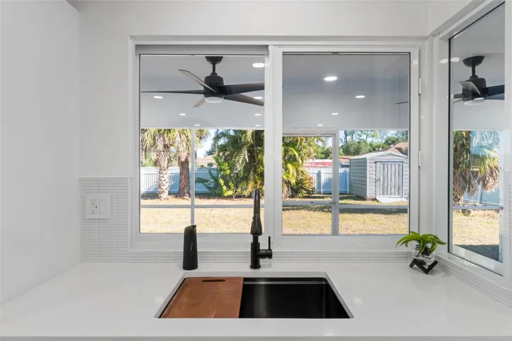 Kitchen sink with pretty backyard view and pass though window to the lanai