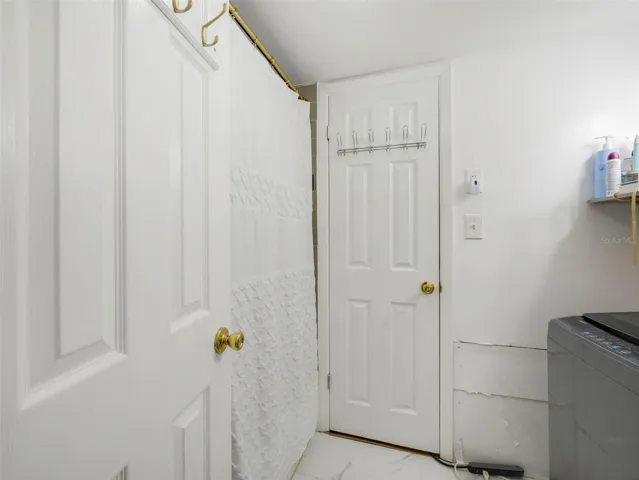 One bathroom is thoughtfully designed to include the home’s laundry space.