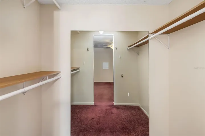 Spacious walk-in closet with built-in shelving and ample storage in the primary suite