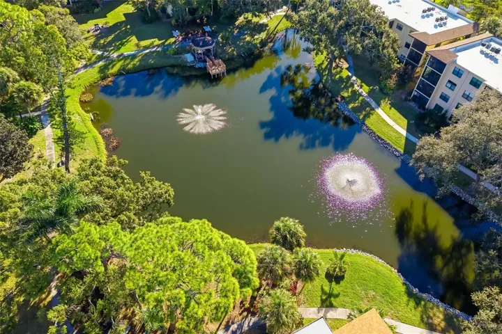 Aerial Pond ViewAerial view of serene pond with fountains and walking paths in DeSoto Square Villas