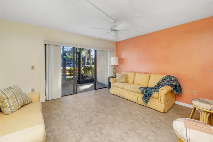 Living room with sliding glass doors leading to screened lanai and garden views