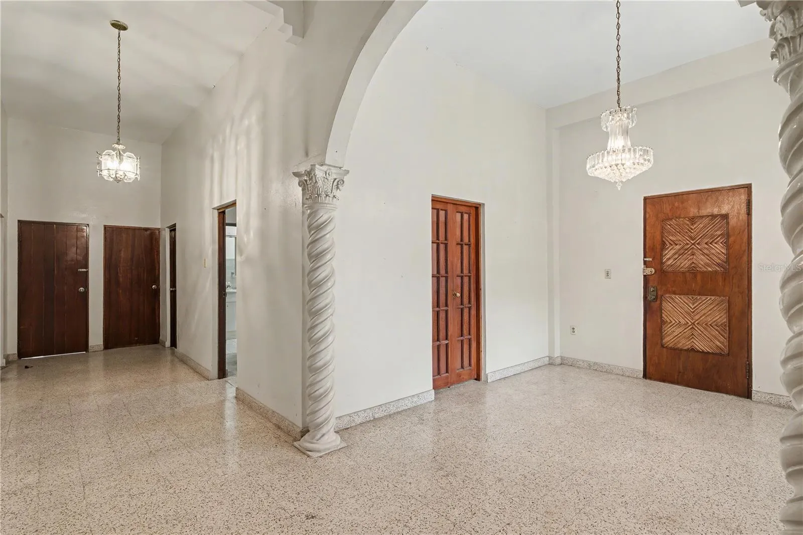 Open interior living area with columns and circulation to multiple roomsinterior arches