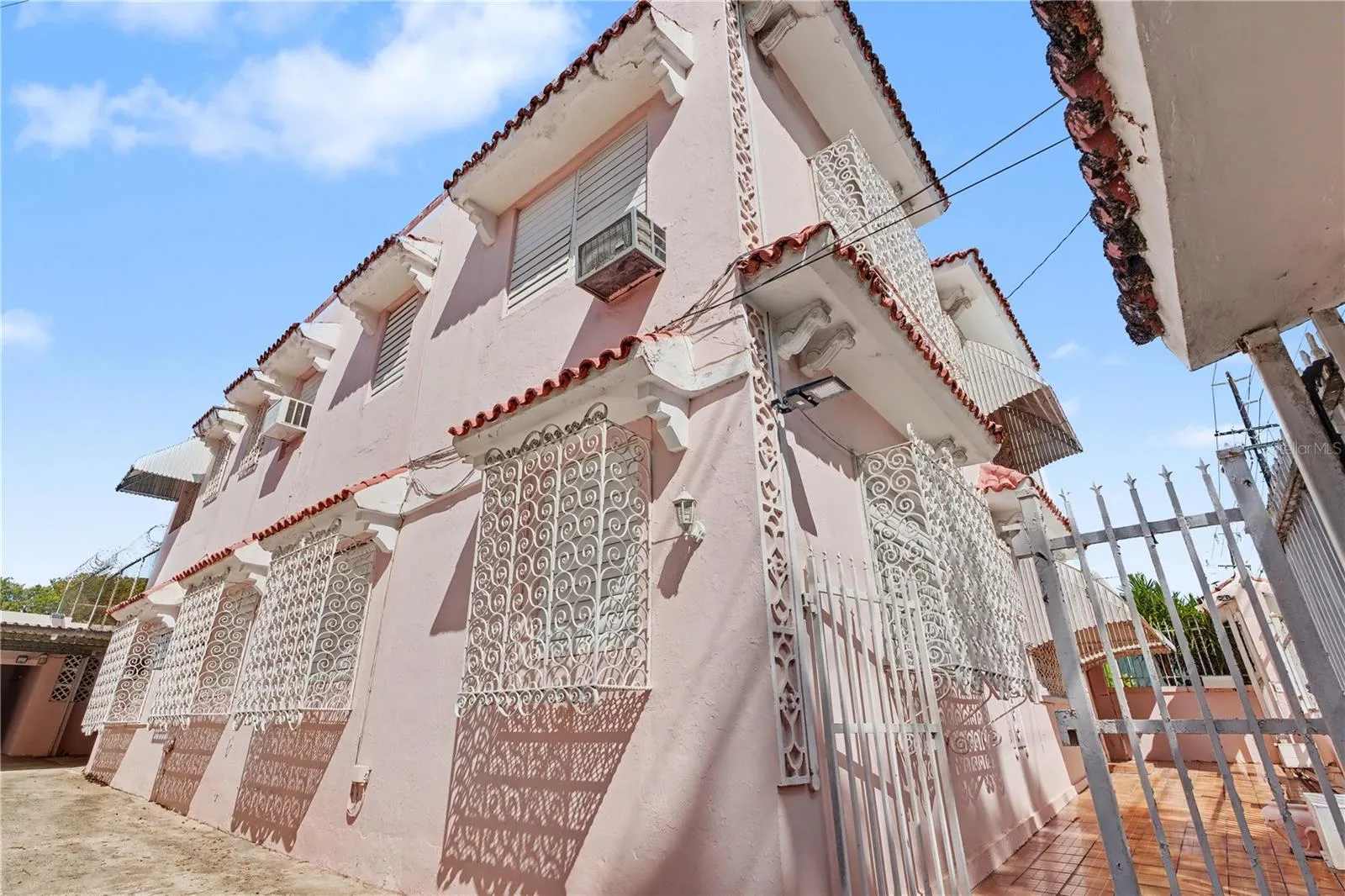 Decorative window railings on historic pink Mediterranean facade