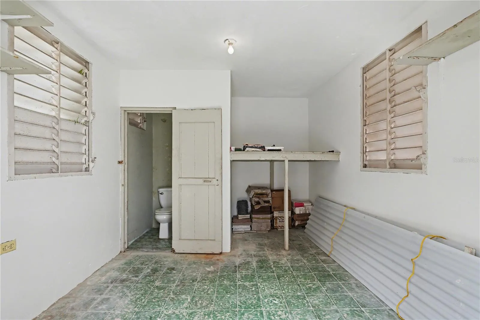 service room or utility room with original Jalousie windows and private bathroom