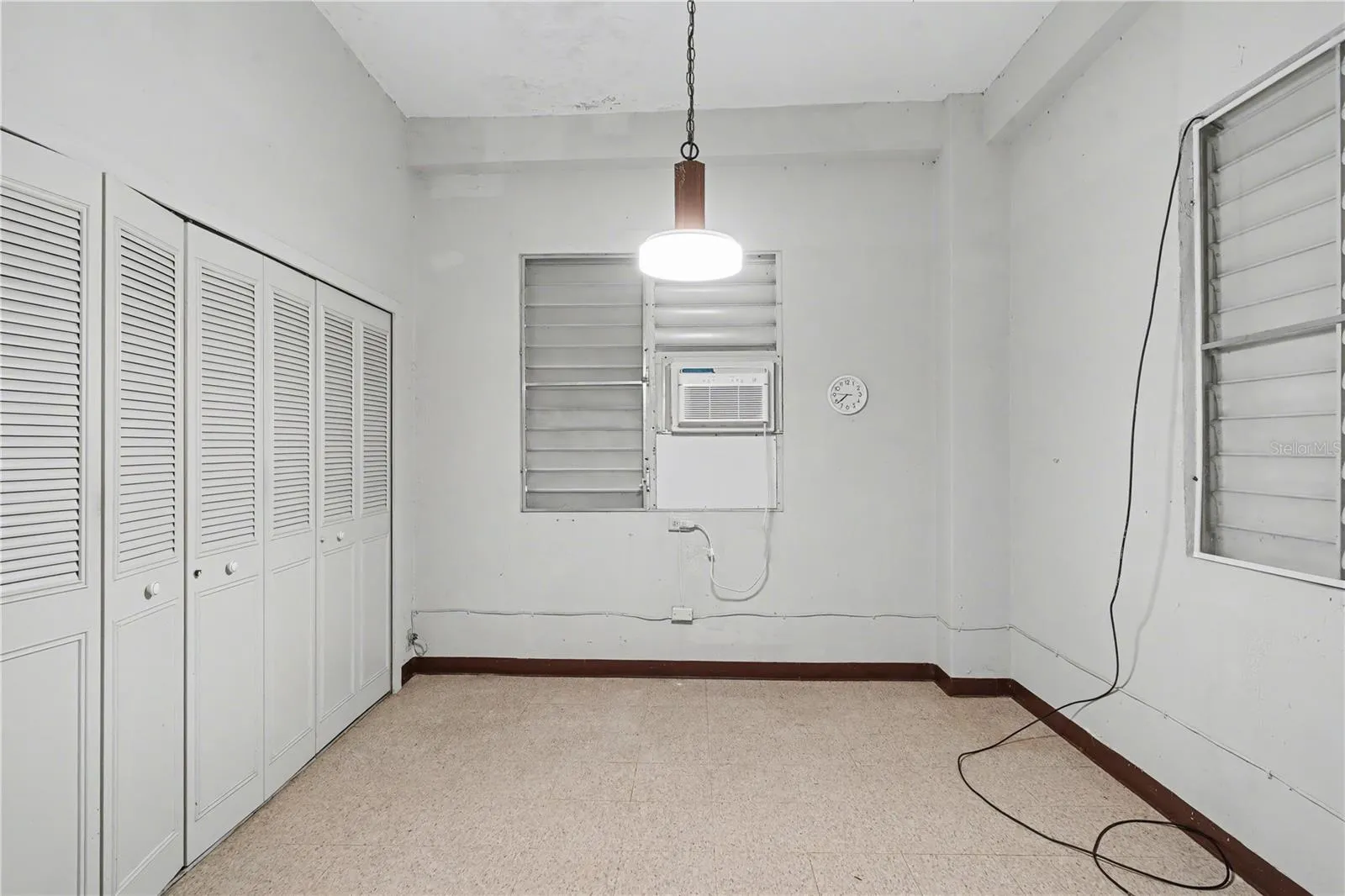 Bedroom with built-in closets and window A/C, suitable for flexible use.