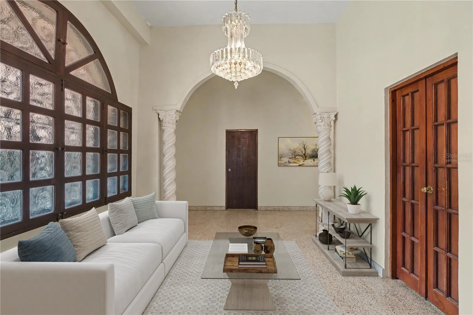 Living area located on the second level of the multi-family home, defined by spiral columns and preserved historic character. Virtually staged.