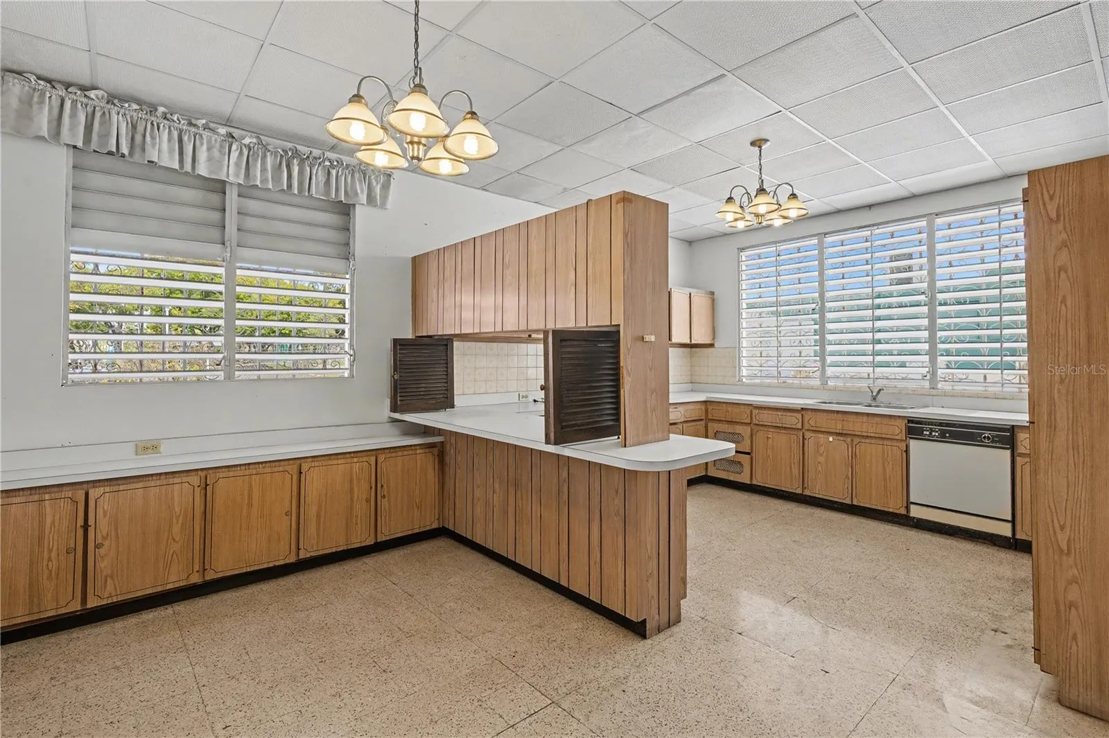 Large kitchen with original cabinetry, natural light, and strong renovation potential.