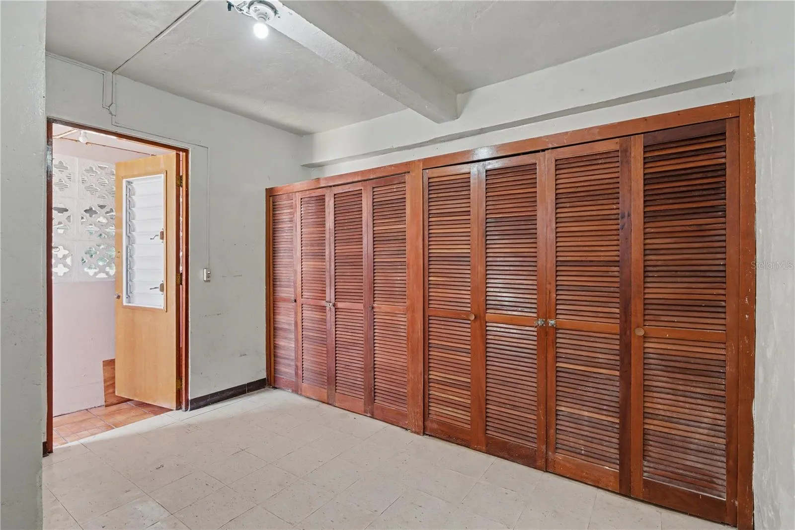Secondary service quarter  room with original jalousie windows and private bathroom, 1940s home
