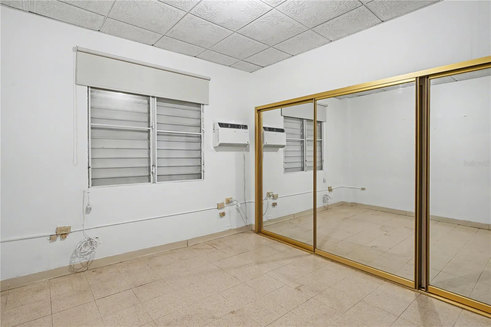 Bedroom with mirrored closet doors offering generous storage and natural light.