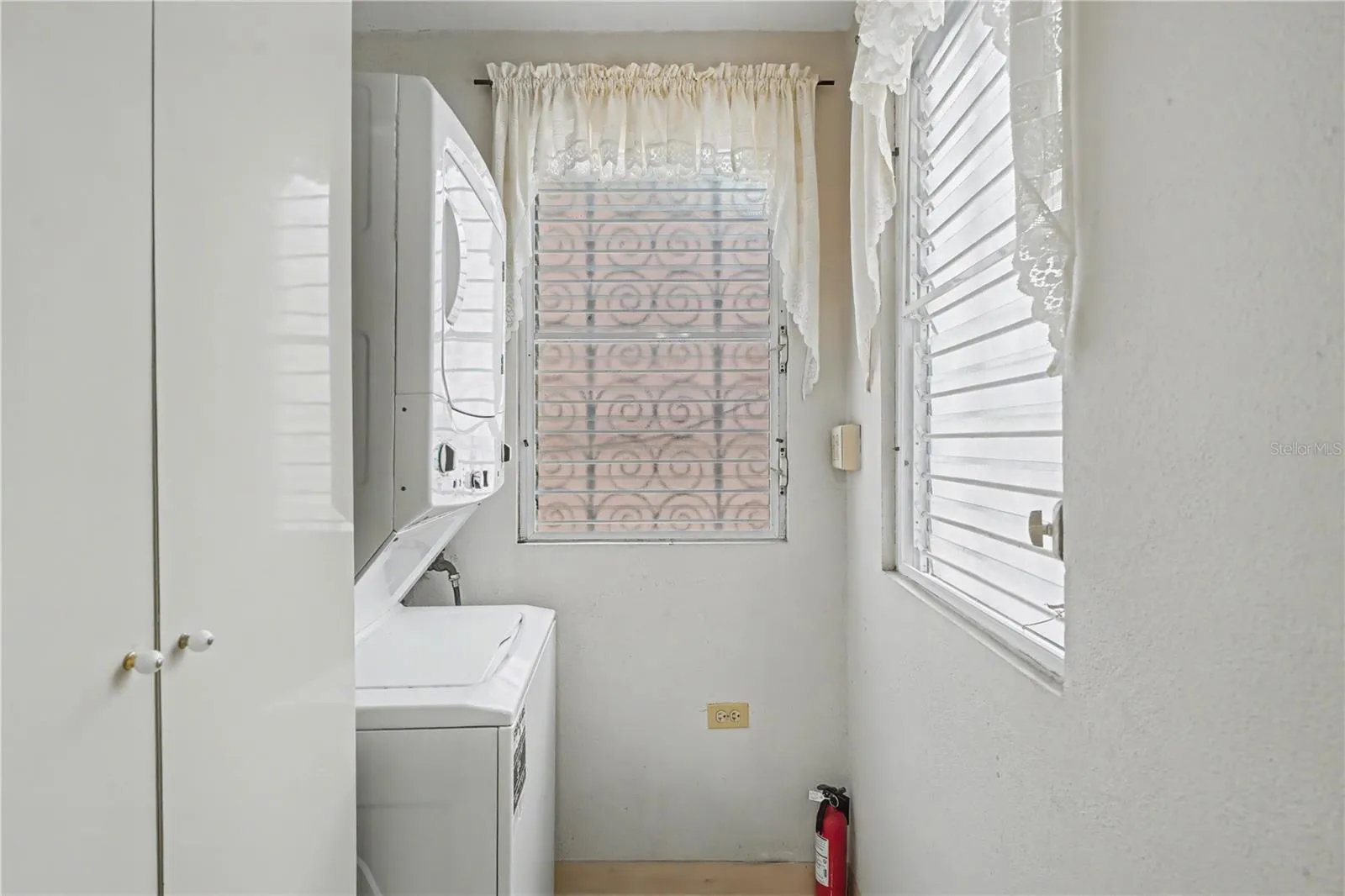 Laundry area with washer, dryer, and natural light from windows