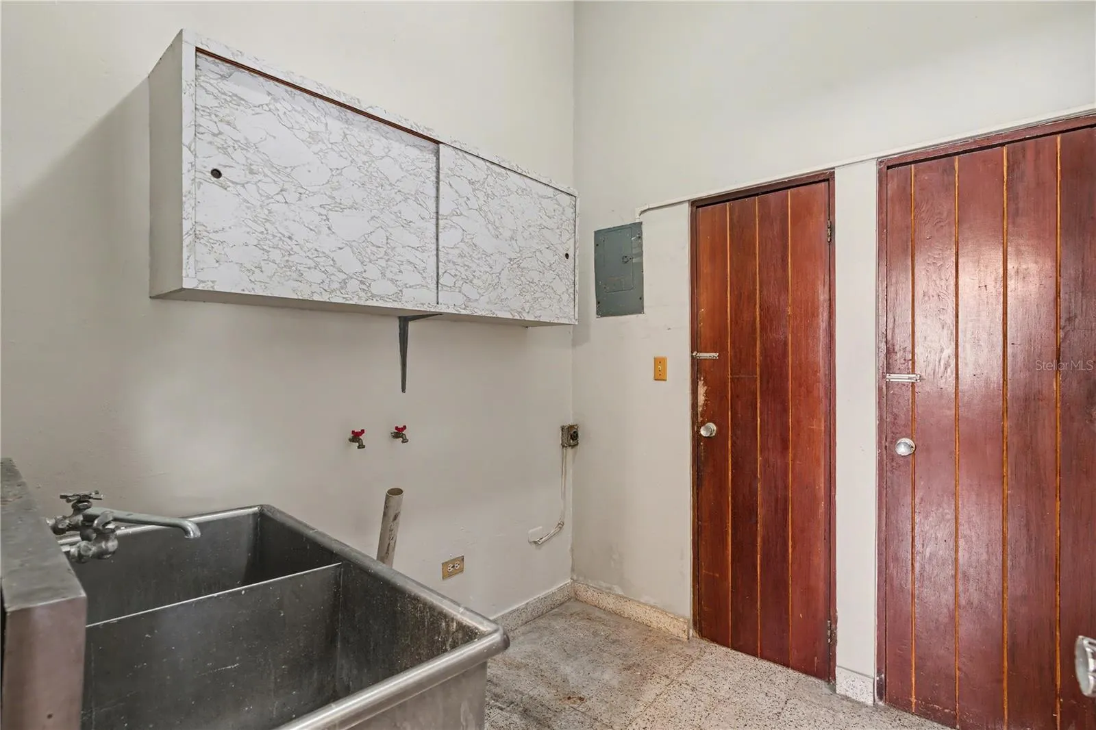 Service or laundry area with utility sink and functional access.