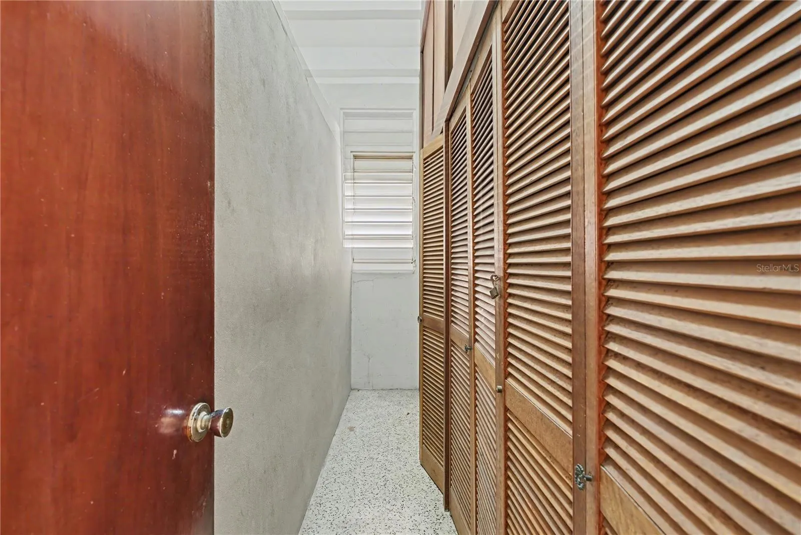 Service hallway with original closets and natural ventilation.