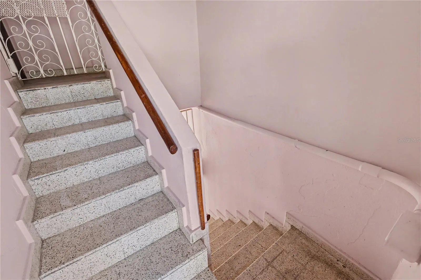 Original terrazzo staircase connecting levels, featuring solid construction and preserved mid-century detailing.