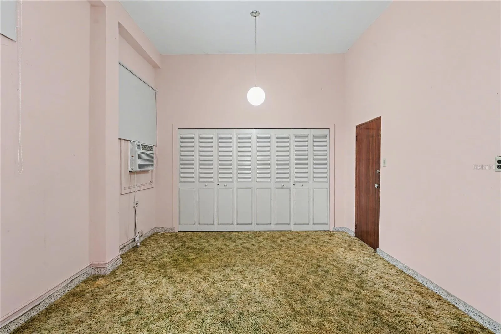 Spacious primary bedroom with original built-in closets and natural light.