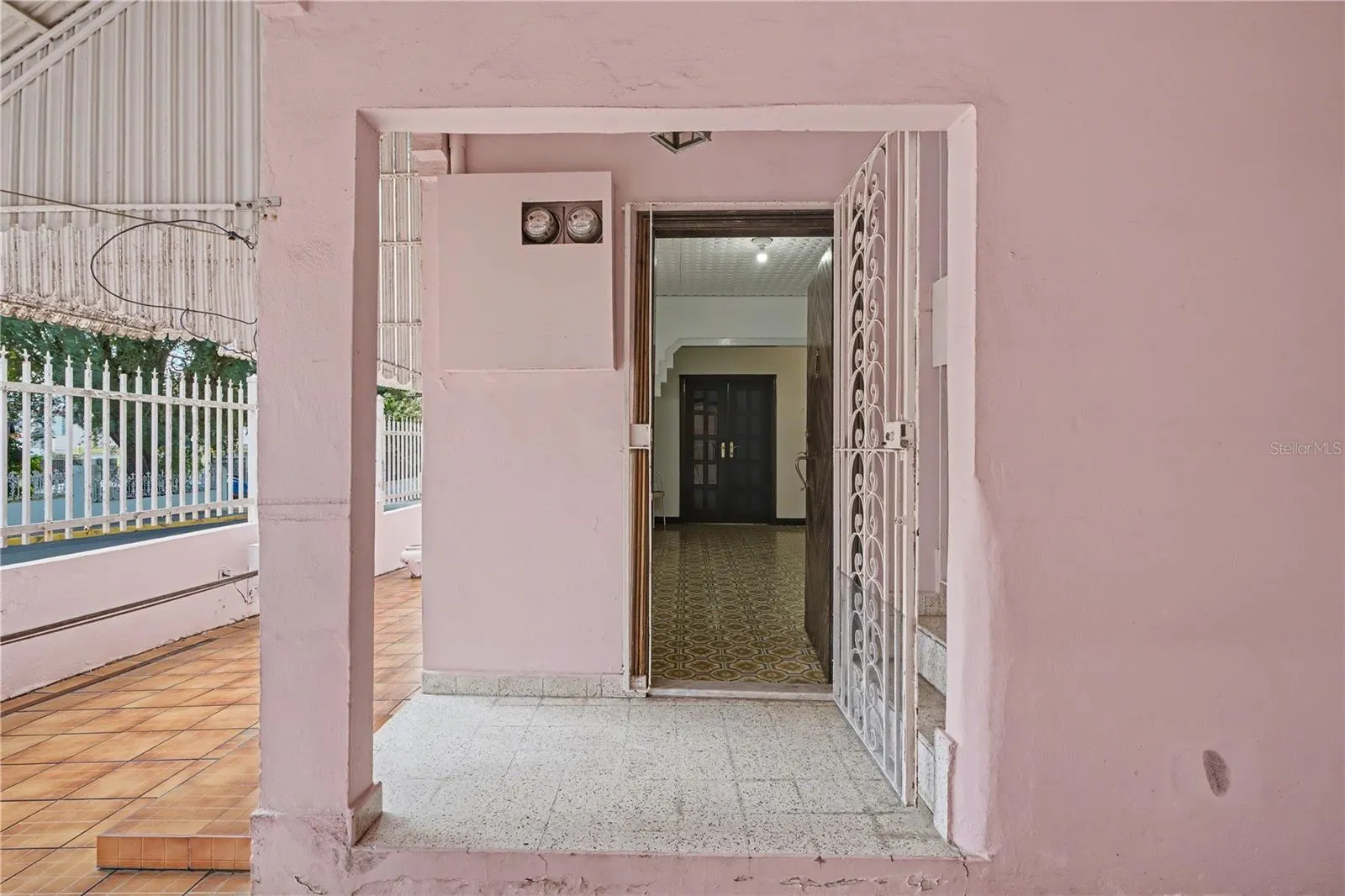 Open wood entry door with terrazzo flooring, historic home
