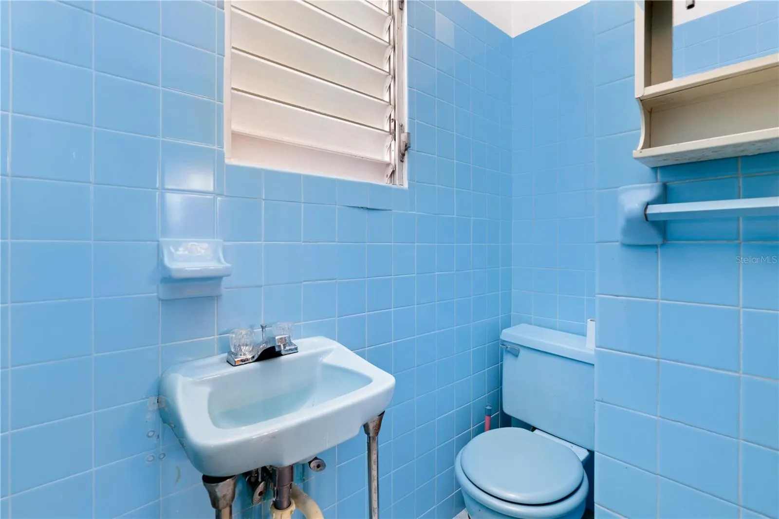 Service bathroom with original tile and efficient, compact layout.