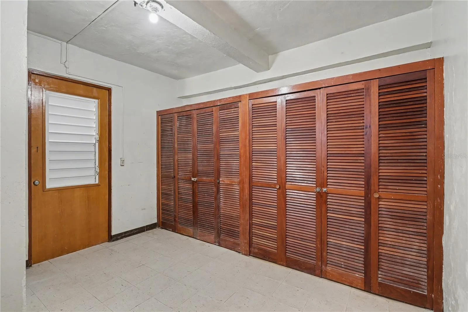 Additional view of secondary service quarter bedroom with original wood closets, 1940s residence