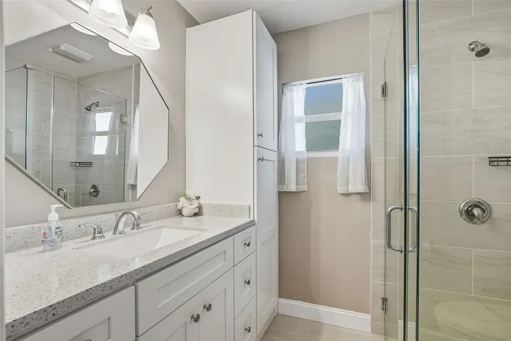 Updated primary ensuite full bath offers tiled stand-alone shower and linen closet for added storage.