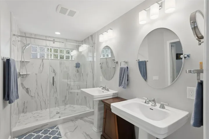 Completely remodeled primary bathroom.  Dual sinks, porcelain tile and custom tile work throughout.