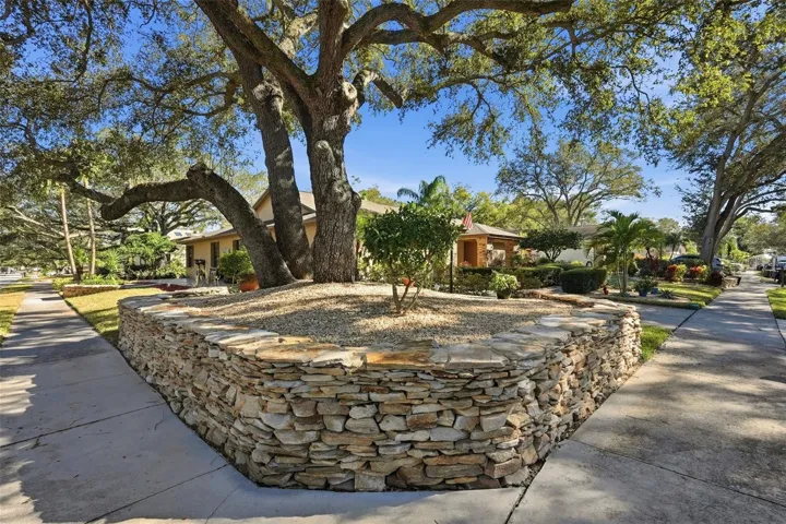 Custom stone wall surrounding the home and landscaping.