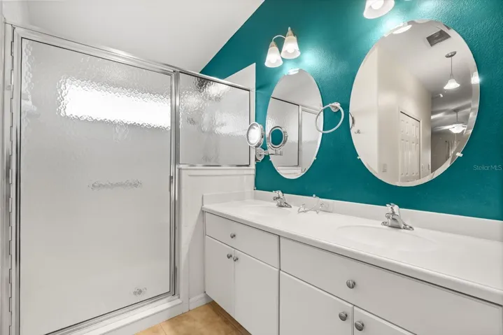 Primary bathroom with dual sinks and walk-in shower