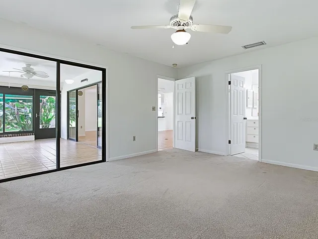 Primary bedroom showing glass doors to Florida room