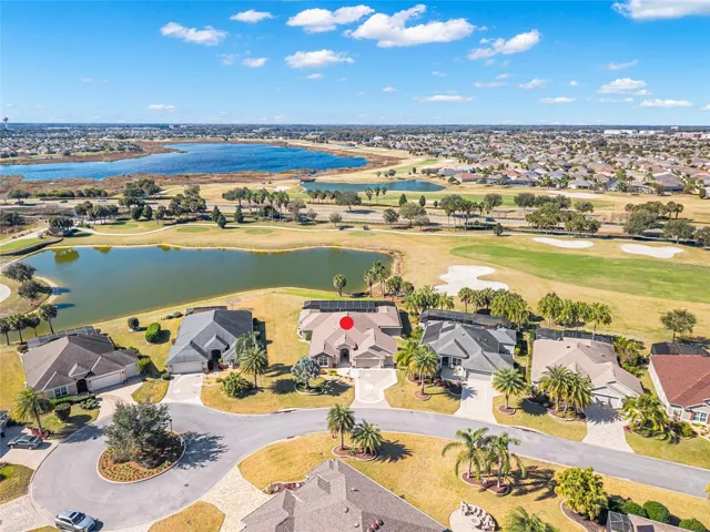 AERIAL looking Southwest - Featuring Evans Prairie Championship Golf Course, Killdeer, Hole 1 - note golf cart path runs behind pond on western side of tees & running parallel w/ Buena Vista Blvd (L center), Brownwood Town Square (water tank visible, deep L), and CR 466A Commercial Corridor (near horizon, deep R)