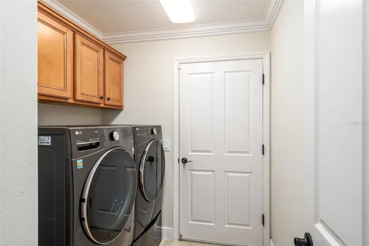 INTERIOR LAUNDRY has a matching WASHER & DRYER set (2021), overhead storage cabinets, and provides access door to the 2.5 car garage.