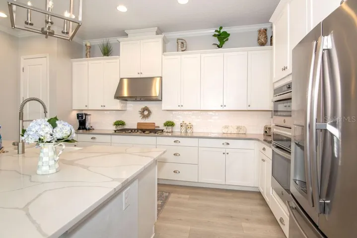 KITCHEN WITH STAINLESS STEEL APPLIANCES, QUARTZ COUNTER-TOPS, BACKSPLASH
