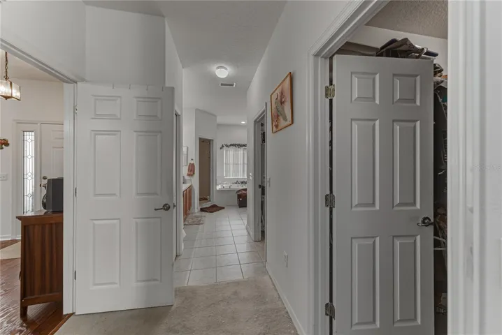 The hallway that connects the primary bedroom with the primary bath has the large walk-in closet and the inside laundry room.