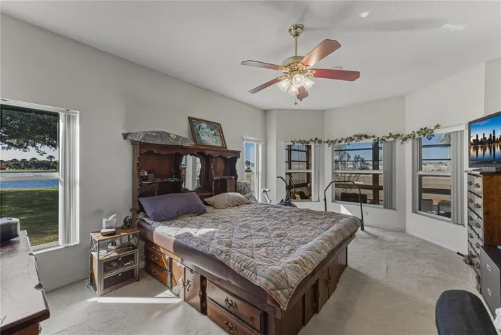 The primary bedroom is at the rear of the home and has carpeting and a ceiling fan with light.