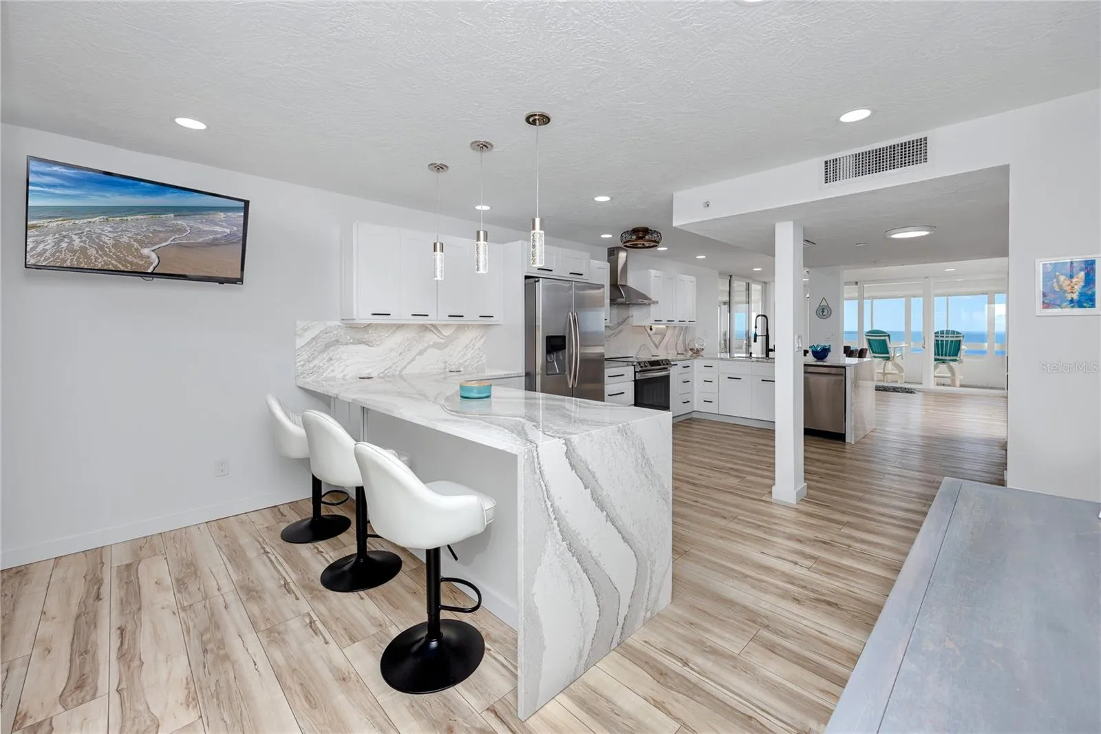Large kitchen with two bar islands complete with waterfall quartz to the floor