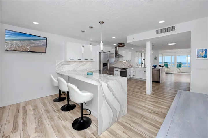 Large kitchen with two bar islands complete with waterfall quartz to the floor