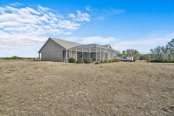 Back of home showing large pool cage, plenty room for all your toys