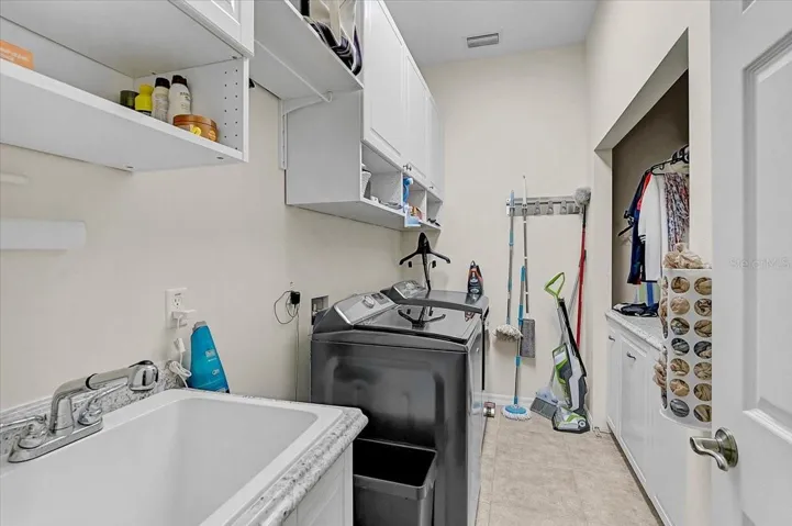 Great laundry room with plenty of storage and work space. Two of the cabinets on the right are pull out laundry bins