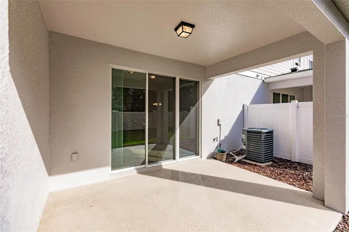 Rear Exterior- Beautiful rear elevation with covered patio, multiple sliding doors.