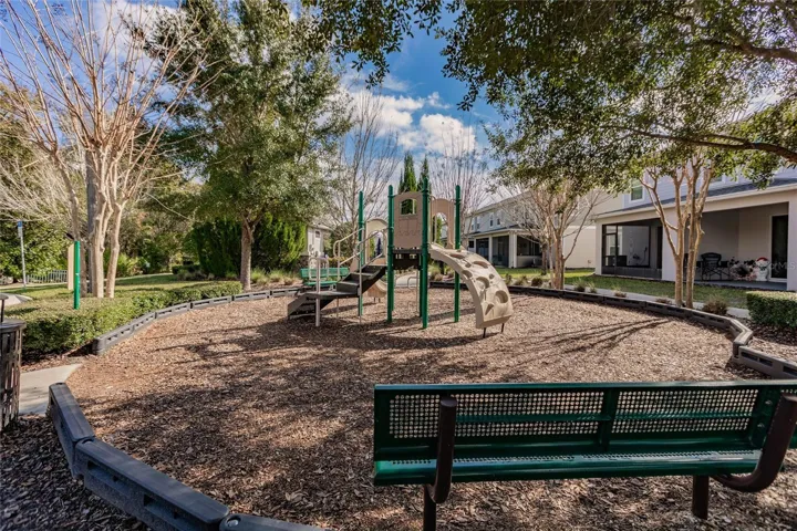 Playground - Shaded neighborhood playground with modern play equipment and seating, perfect for families and outdoor fun.