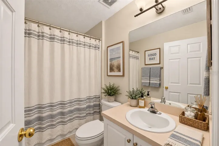 One of three full bathrooms, virtually staged
