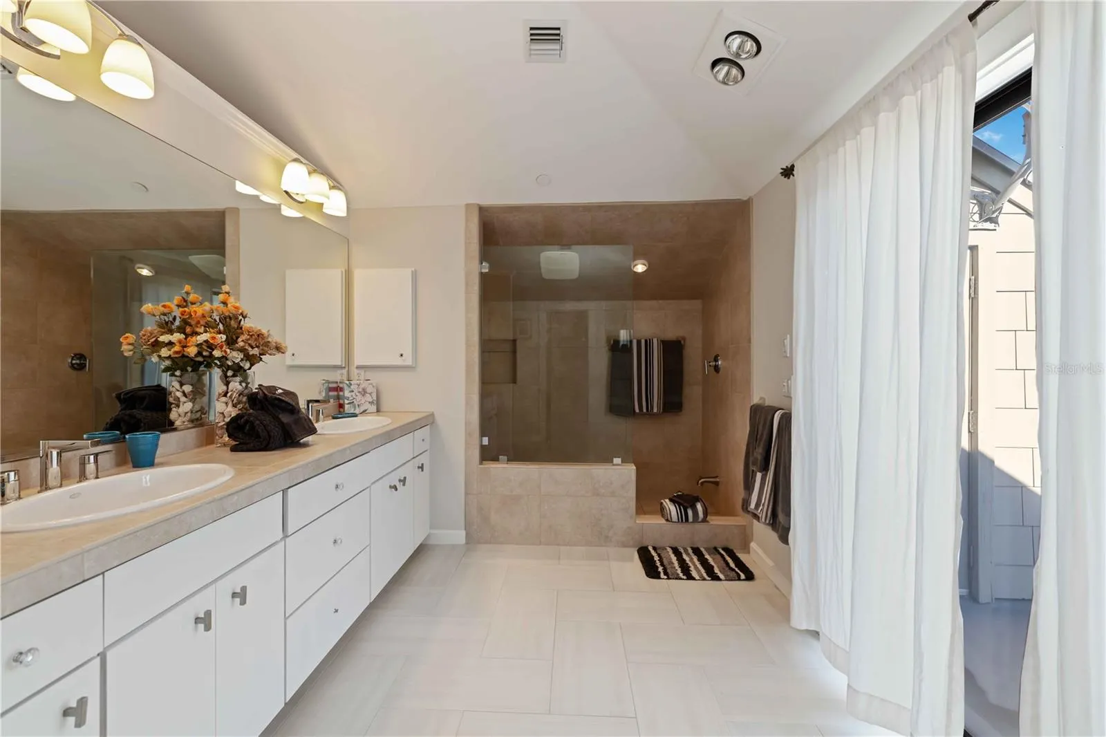 Primary bath with double bowl sinks and private balcony