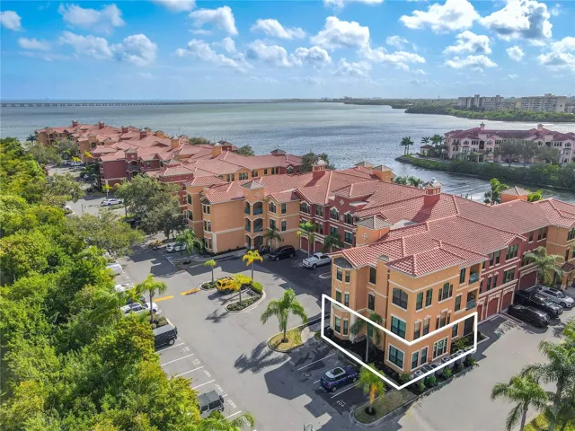 An aerial perspective showcases the prime waterfront setting of The Grand Bellagio at Baywatch, nestled along Old Tampa Bay. Residents enjoy a resort-style environment with lush grounds, Mediterranean-style buildings, and easy access to scenic walking paths, water views, and community amenities.