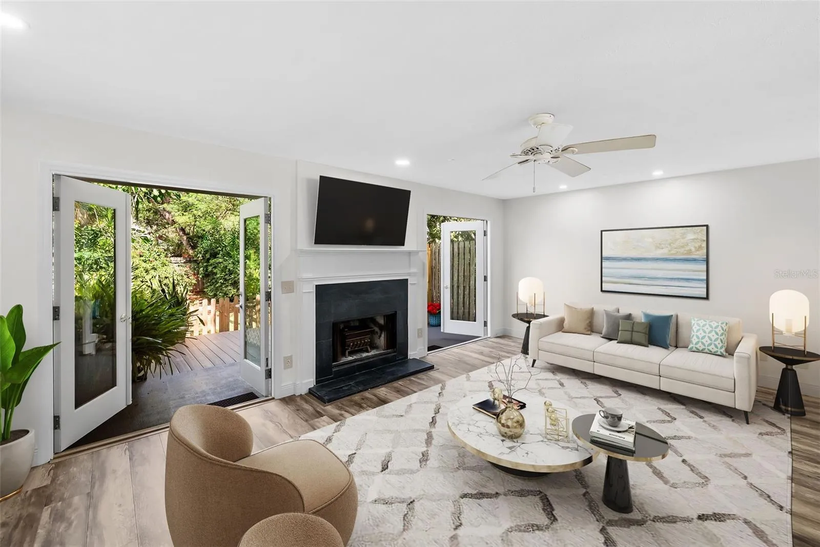 Large open living room w/ doors to the patio (staged)