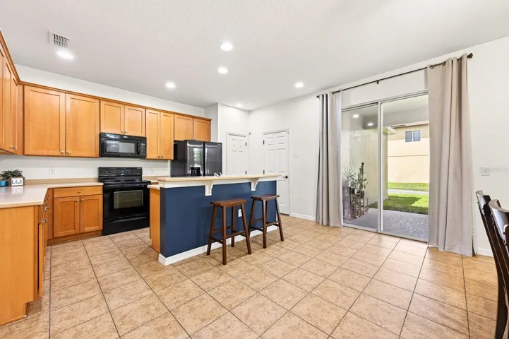 Open kitchen and dining, sliding glass doors open to the covered lanai.