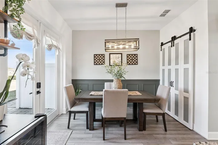 Dining Room with Upgraded Light Fixtures, Wood Work, and Custom Pantry Barn Doors